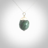 This picture shows a little jade acorn pendant with sterling silver chain. The cap is sterling silver and is embossed with some decorative markings which give the silver cap some detail and character. Hand made by Ana Krakosky.